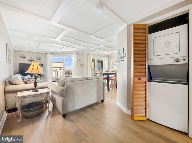 living room with coffered ceiling, stacked washing maching and dryer, light wood-type flooring, and ceiling fan