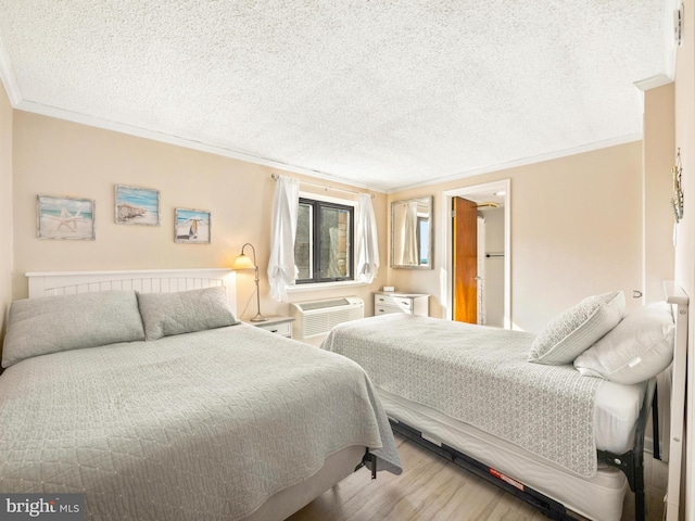 bedroom featuring a textured ceiling, a wall unit AC, ornamental molding, and wood-type flooring