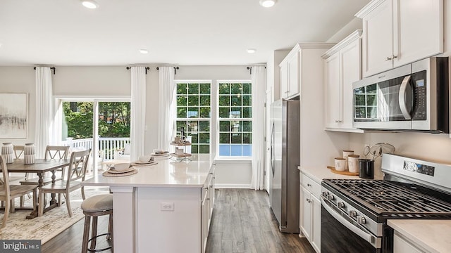 kitchen featuring white cabinets, a center island, a healthy amount of sunlight, and appliances with stainless steel finishes