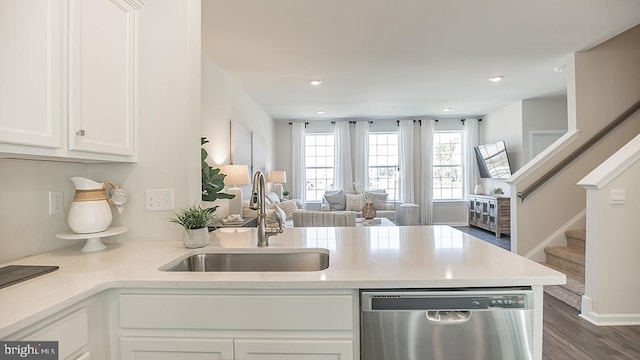 kitchen featuring sink, dark wood-type flooring, stainless steel dishwasher, kitchen peninsula, and white cabinets