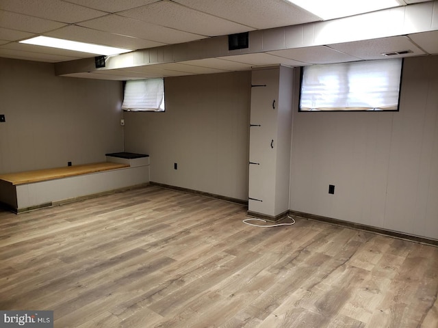 basement featuring light hardwood / wood-style floors and a drop ceiling