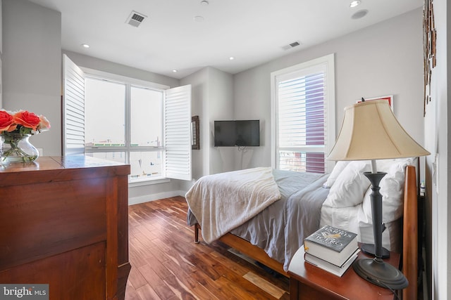 bedroom featuring hardwood / wood-style flooring and multiple windows