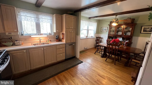 kitchen featuring appliances with stainless steel finishes, sink, light wood-type flooring, light brown cabinets, and beam ceiling