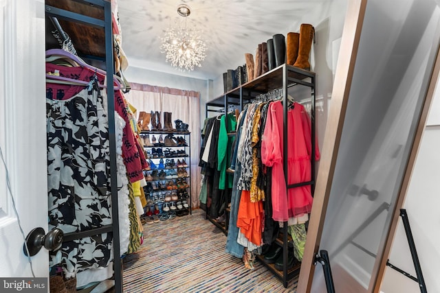 spacious closet featuring an inviting chandelier