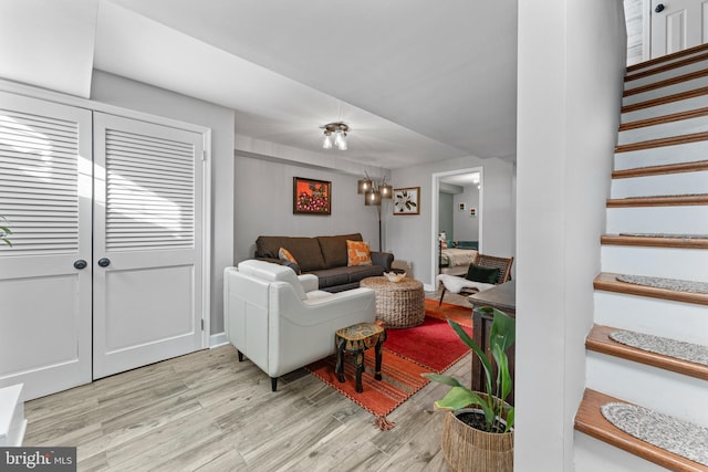 living room featuring light wood-type flooring and a chandelier