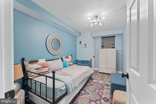 bedroom featuring an inviting chandelier and hardwood / wood-style flooring