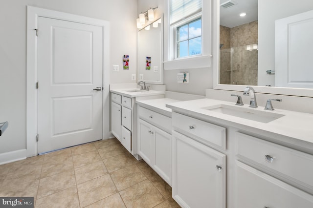 bathroom featuring tile patterned floors, visible vents, a tile shower, and vanity