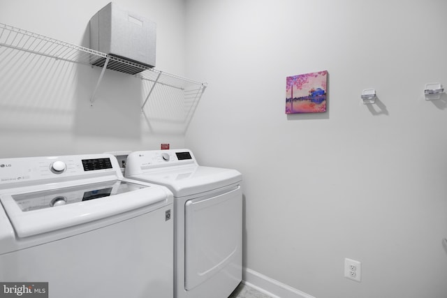 clothes washing area featuring laundry area, baseboards, and washing machine and clothes dryer