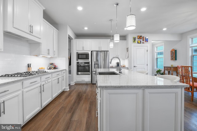 kitchen with white cabinetry, appliances with stainless steel finishes, dark wood-type flooring, and a sink