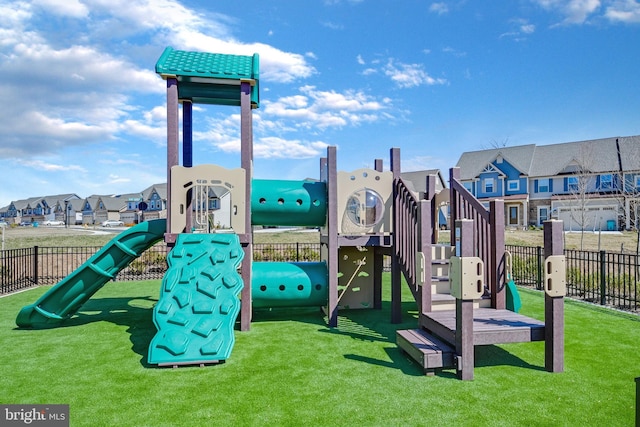 community play area with a lawn, fence, and a residential view