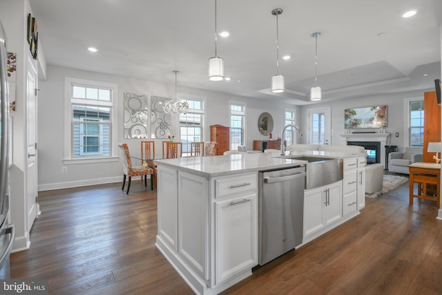 kitchen featuring stainless steel dishwasher, dark wood-type flooring, open floor plan, white cabinetry, and a sink