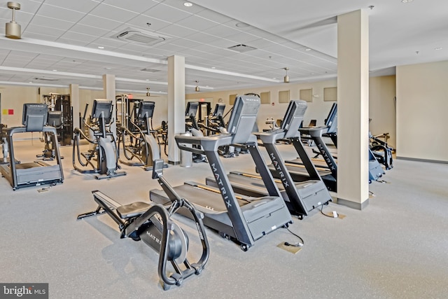 workout area featuring a drop ceiling, visible vents, and baseboards