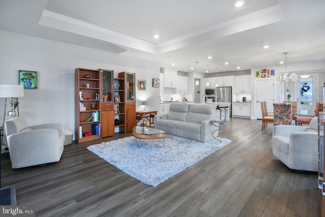 living room with ornamental molding, a tray ceiling, dark wood-style flooring, and recessed lighting