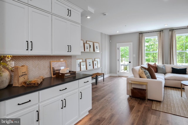 kitchen featuring hardwood / wood-style flooring, white cabinets, and decorative backsplash