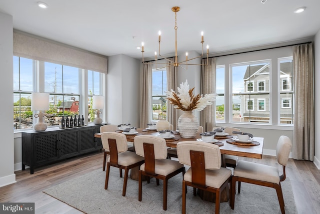 dining area featuring a wealth of natural light, a chandelier, and light hardwood / wood-style flooring