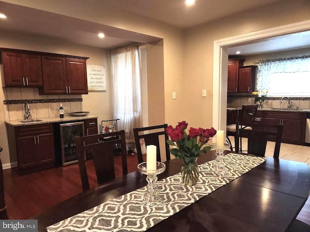 dining room featuring wine cooler, sink, and wood-type flooring