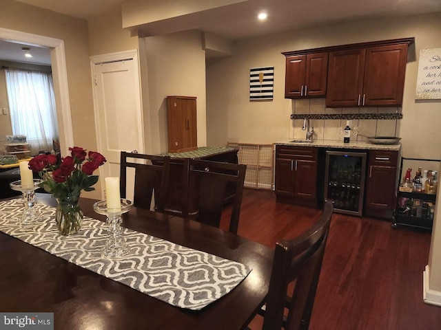 dining space featuring wet bar, beverage cooler, and dark wood-type flooring