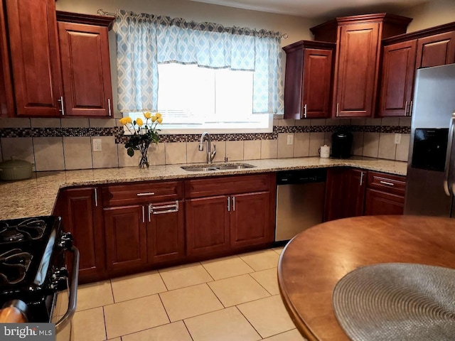 kitchen with decorative backsplash, light stone countertops, sink, and appliances with stainless steel finishes