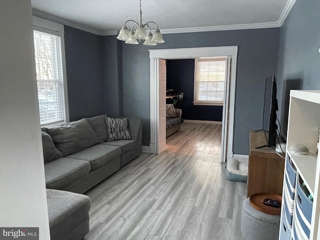 living room with wood-type flooring, crown molding, and a notable chandelier