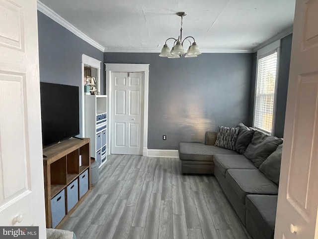 living room with a chandelier, light hardwood / wood-style flooring, and ornamental molding