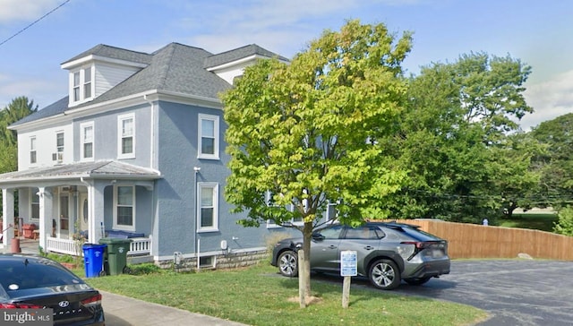 view of property exterior with a lawn and a porch