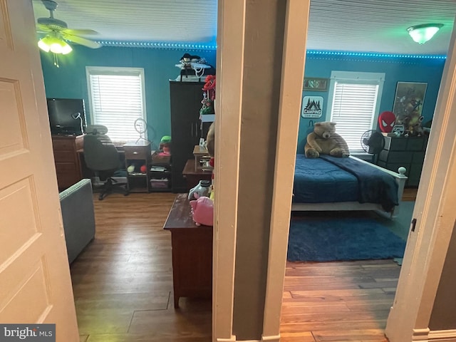 bedroom with multiple windows, hardwood / wood-style flooring, and ceiling fan