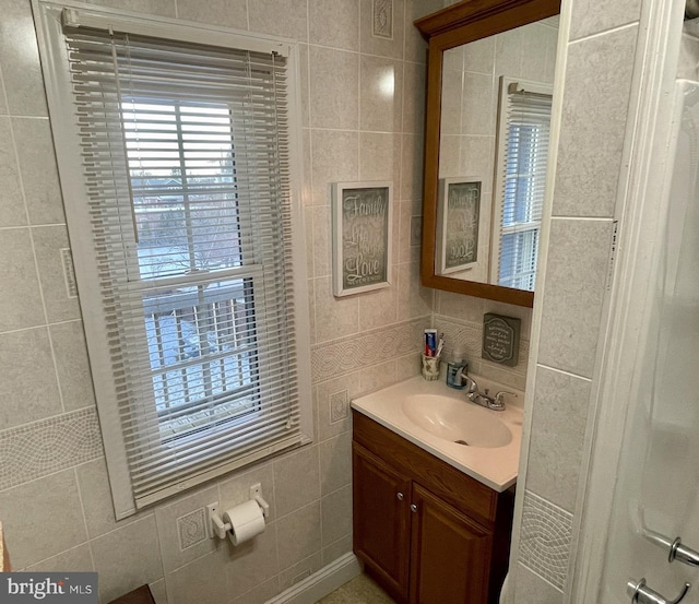 bathroom with vanity and tile walls