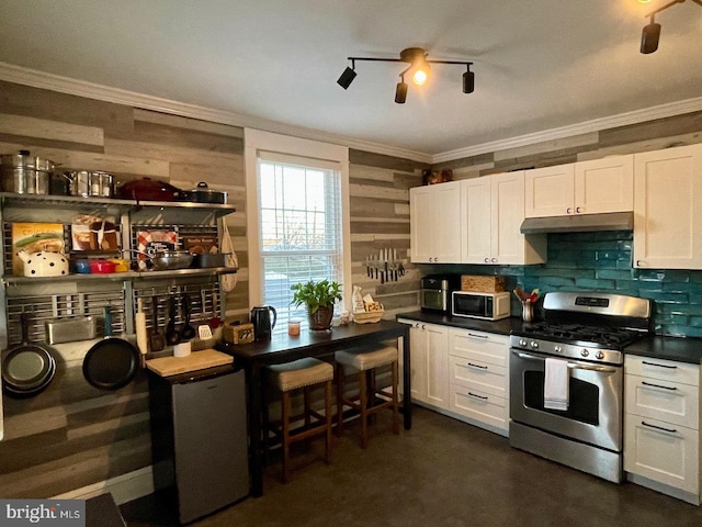 kitchen with gas stove, white cabinetry, and refrigerator