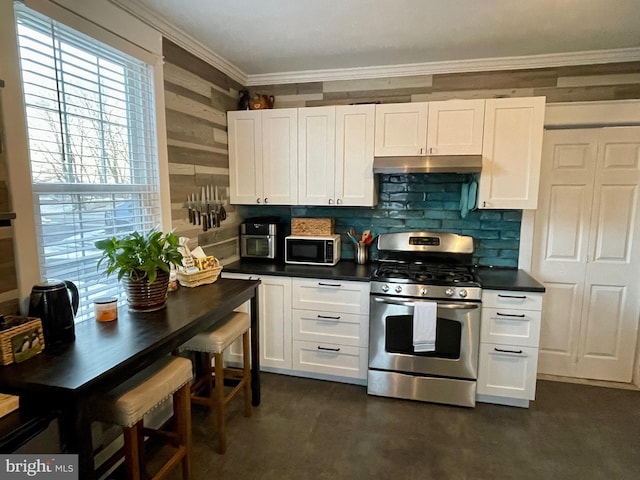 kitchen with decorative backsplash, gas stove, white cabinetry, and ornamental molding