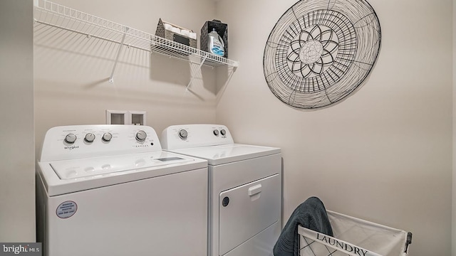 clothes washing area with washer and clothes dryer