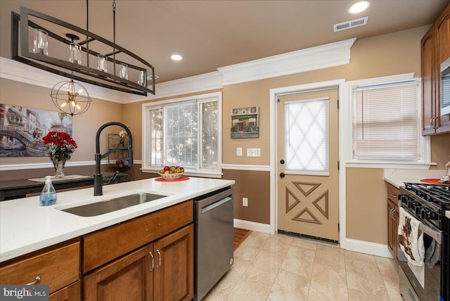 kitchen with crown molding, appliances with stainless steel finishes, sink, and hanging light fixtures