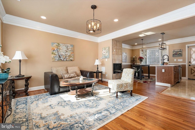 living room with an inviting chandelier, ornamental molding, dark hardwood / wood-style floors, and sink