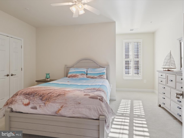 carpeted bedroom featuring ceiling fan and a closet