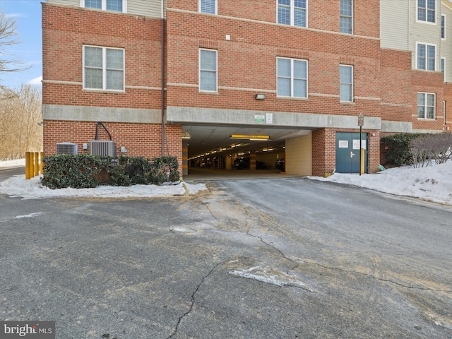 snow covered property with central air condition unit