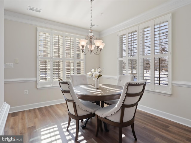 dining room featuring hardwood / wood-style flooring, ornamental molding, and a chandelier