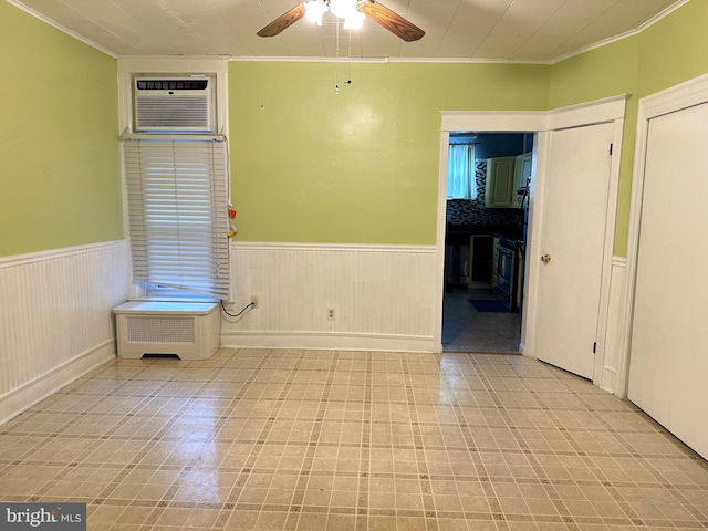 empty room featuring ceiling fan, an AC wall unit, and crown molding