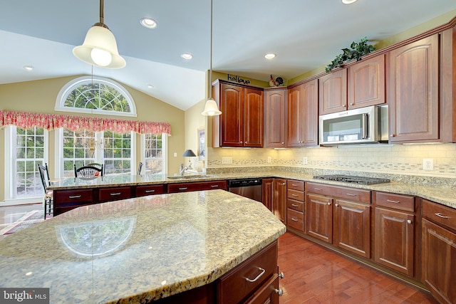 kitchen featuring appliances with stainless steel finishes, pendant lighting, lofted ceiling, light stone counters, and dark wood-type flooring