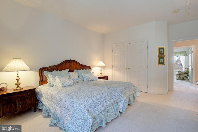 bedroom with light colored carpet and a closet