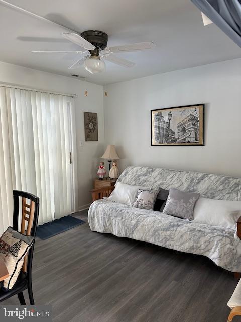 living room with ceiling fan and dark hardwood / wood-style flooring