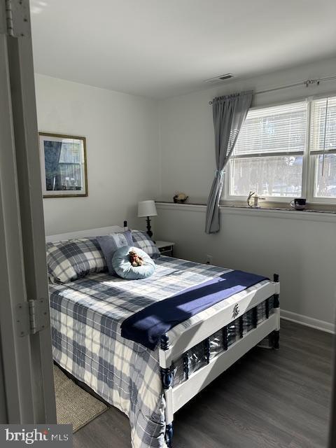 bedroom with dark hardwood / wood-style floors