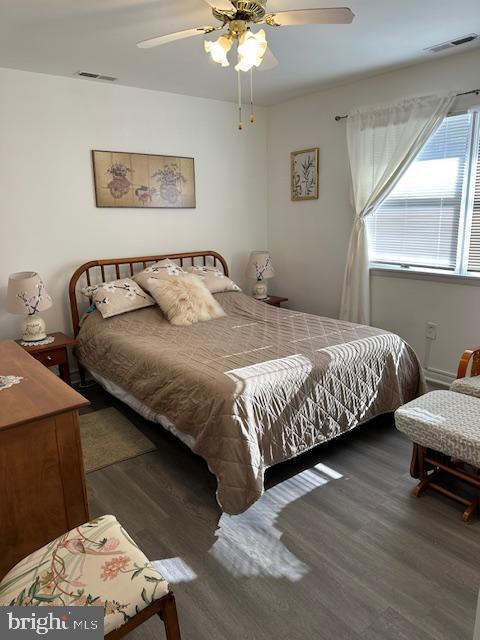 bedroom with ceiling fan and dark wood-type flooring