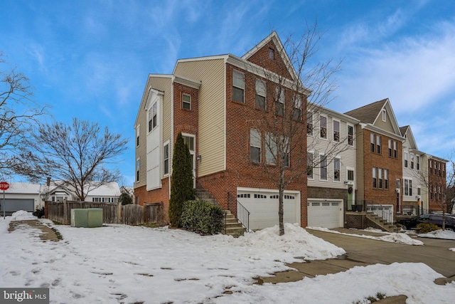 snow covered property with a garage