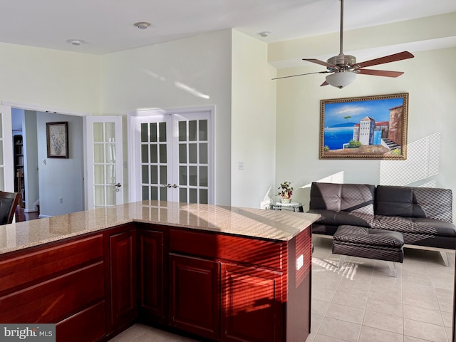 kitchen with light stone countertops, french doors, ceiling fan, and light tile patterned flooring