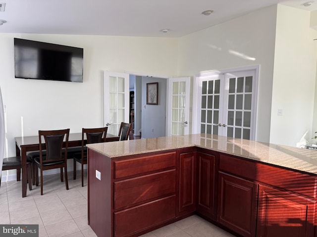 kitchen featuring light stone counters, french doors, and light tile patterned flooring