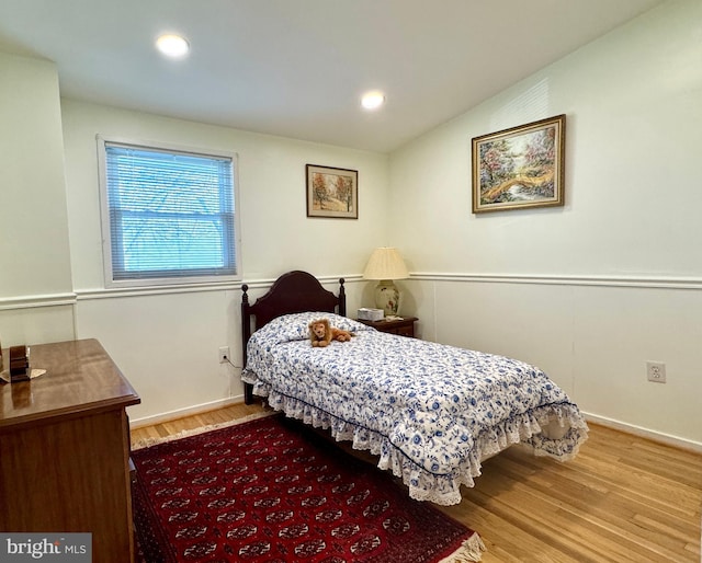 bedroom with wood-type flooring and vaulted ceiling