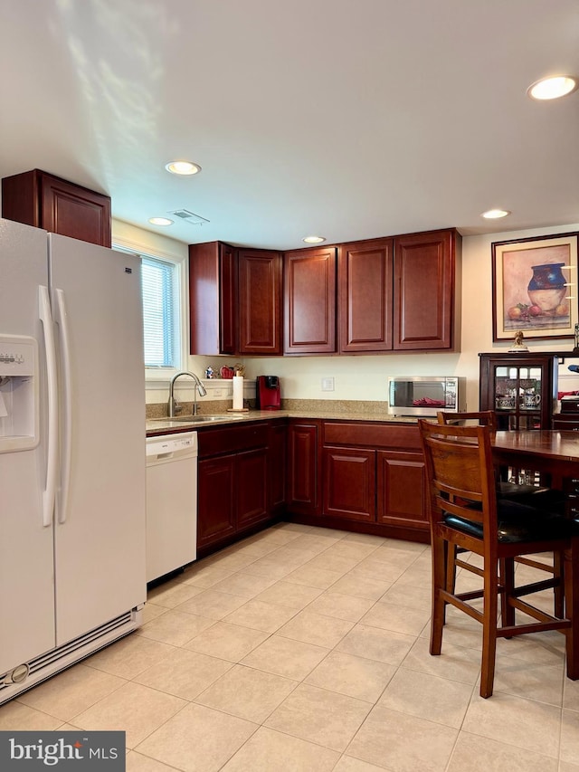 kitchen with white appliances, sink, and light tile patterned floors