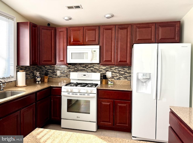 kitchen with sink, white appliances, light tile patterned flooring, and backsplash