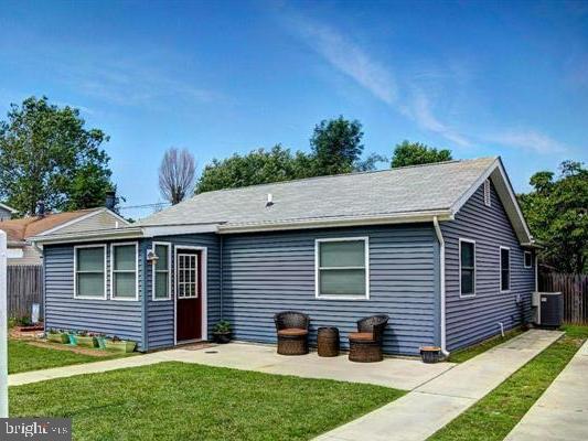 single story home with central air condition unit and a front lawn