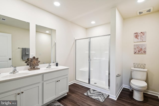 bathroom featuring hardwood / wood-style flooring, toilet, walk in shower, and vanity