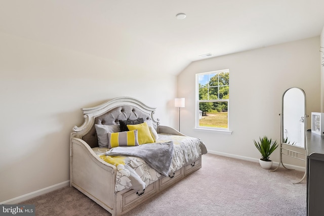 bedroom with vaulted ceiling and light carpet